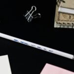 white and pink paper on black surface