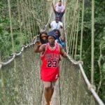 a group of people walking across a suspension bridge