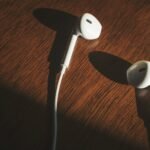 white earbuds on brown wooden table
